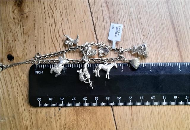 925 silver charm bracelet with intricate designs, weighing 27.3g, showcasing detailed metalwork and elegant craftsmanship.