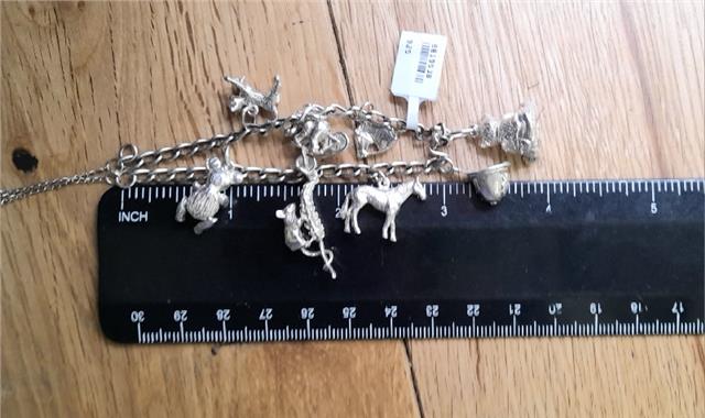 925 silver charm bracelet with intricate designs, weighs 27.3g, unbranded jewelry accessory featuring detailed charms and links.
