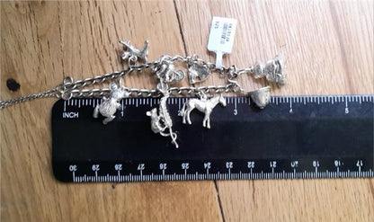 925 silver charm bracelet with intricate designs, weighs 27.3g, unbranded jewelry accessory featuring detailed charms and links.