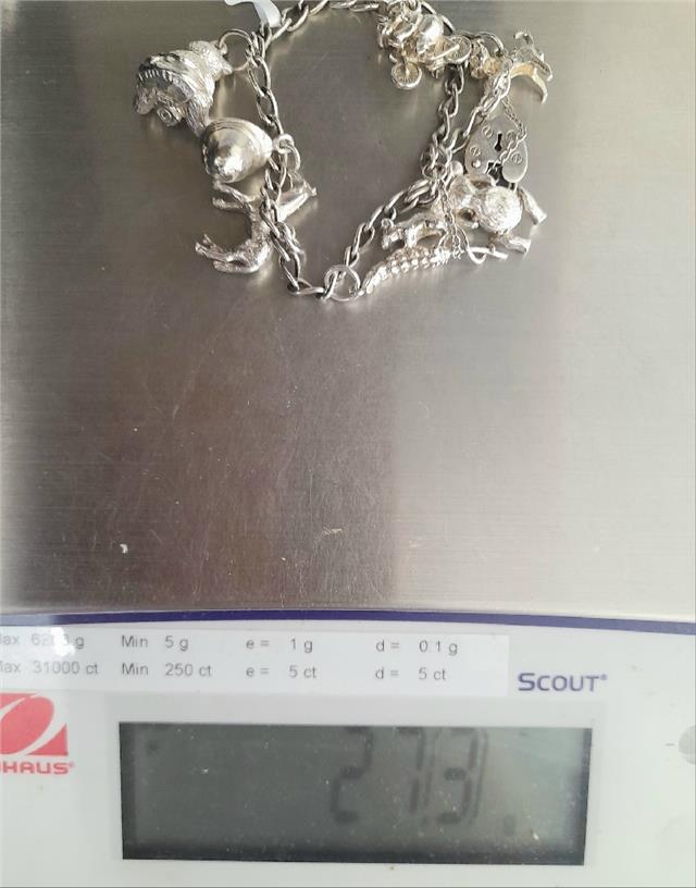 925 silver charm bracelet with intricate designs, weighing 27.3g, crafted with detailed charms and high-quality silver.