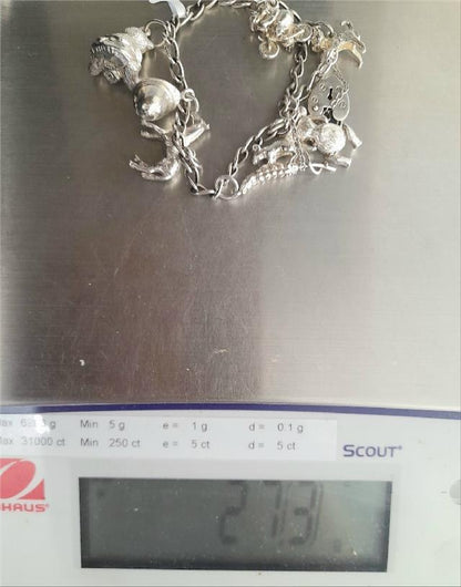925 silver charm bracelet with intricate designs, weighing 27.3g, crafted with detailed charms and high-quality silver.