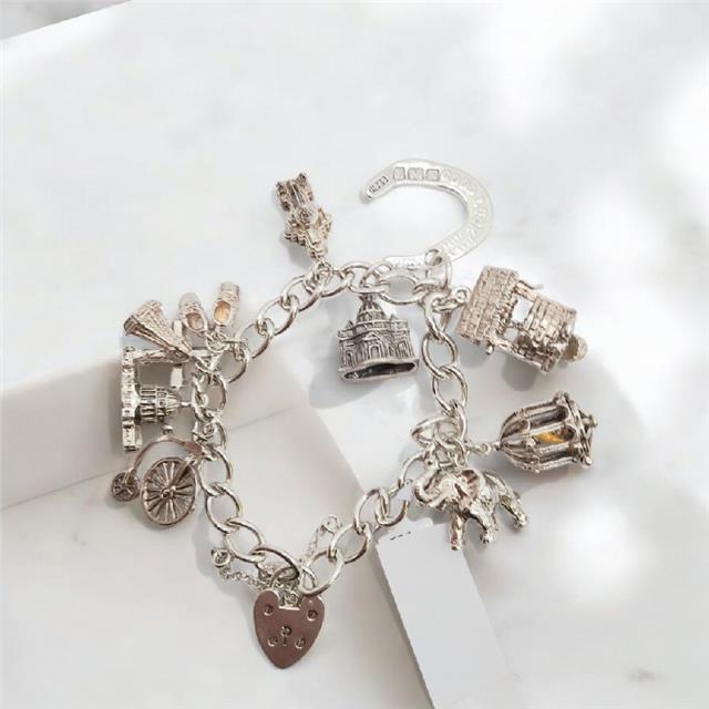 925 silver charm bracelet weighing 53.6g, 7 inches long, featuring various charms and detailed silver craftsmanship.