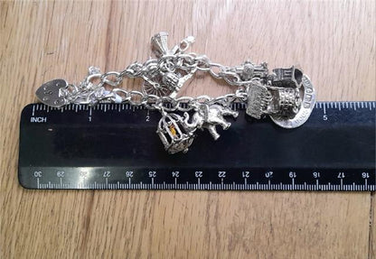 925 silver charm bracelet weighing 53.6g and measuring 7 inches, featuring intricate charm details and a secure clasp.