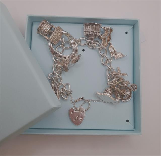 925 silver charm bracelet, 7-inch unbranded jewelry piece with intricate charms and 53.6g weight displayed on a neutral background.