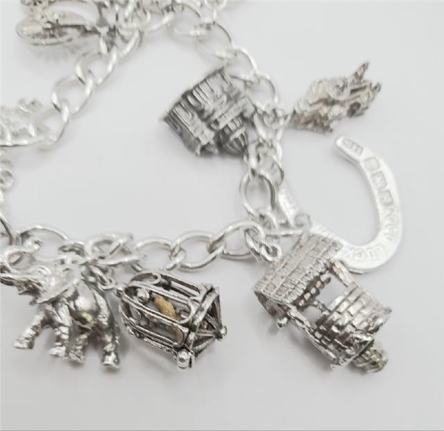 925 silver charm bracelet weighing 53.6g, 7 inches long, featuring various charms, unbranded jewelry accessory.