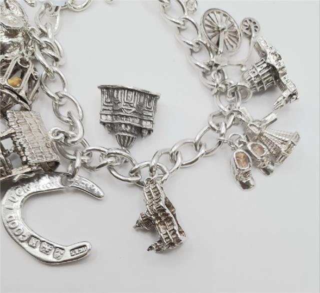 925 silver charm bracelet, 7-inch length, unbranded, 53.6g, featuring detailed silver charms and links.