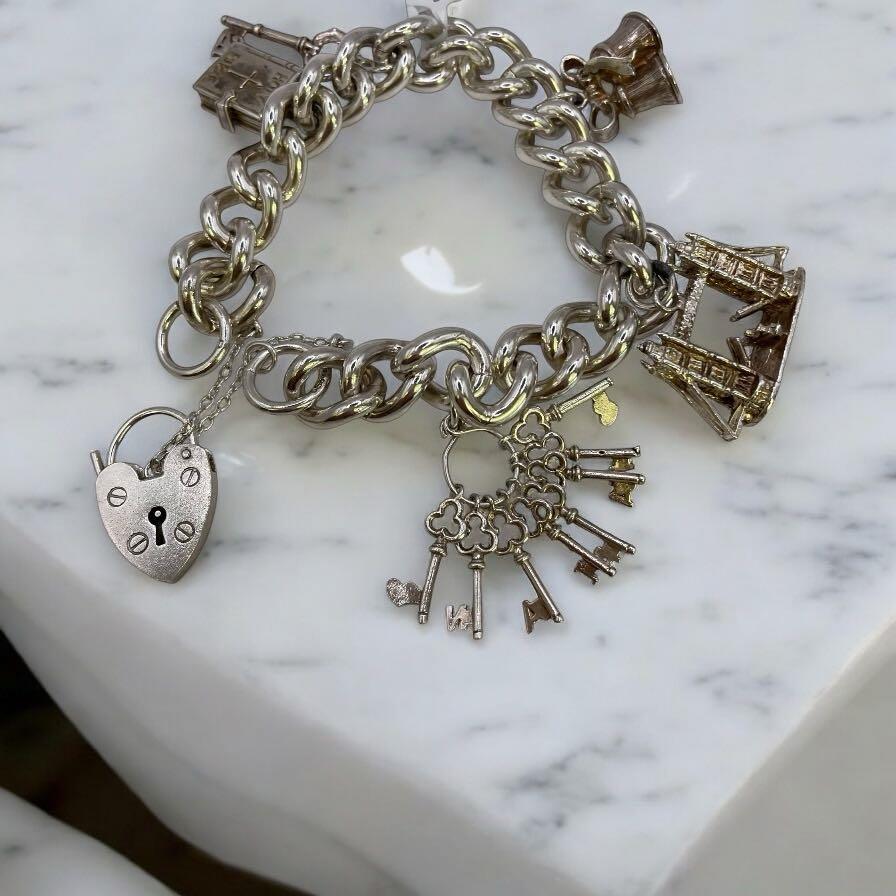925 silver charm bracelet with decorative charms, unbranded jewelry accessory, shown on a plain background.