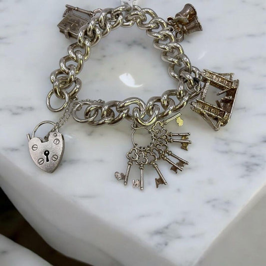 925 silver charm bracelet with decorative charms, unbranded jewelry accessory, shown on a plain background.