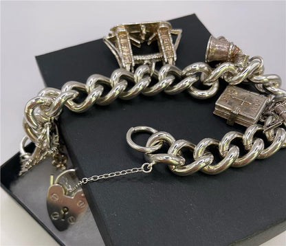 925 silver charm bracelet with various decorative charms, unbranded jewelry piece on a white background.