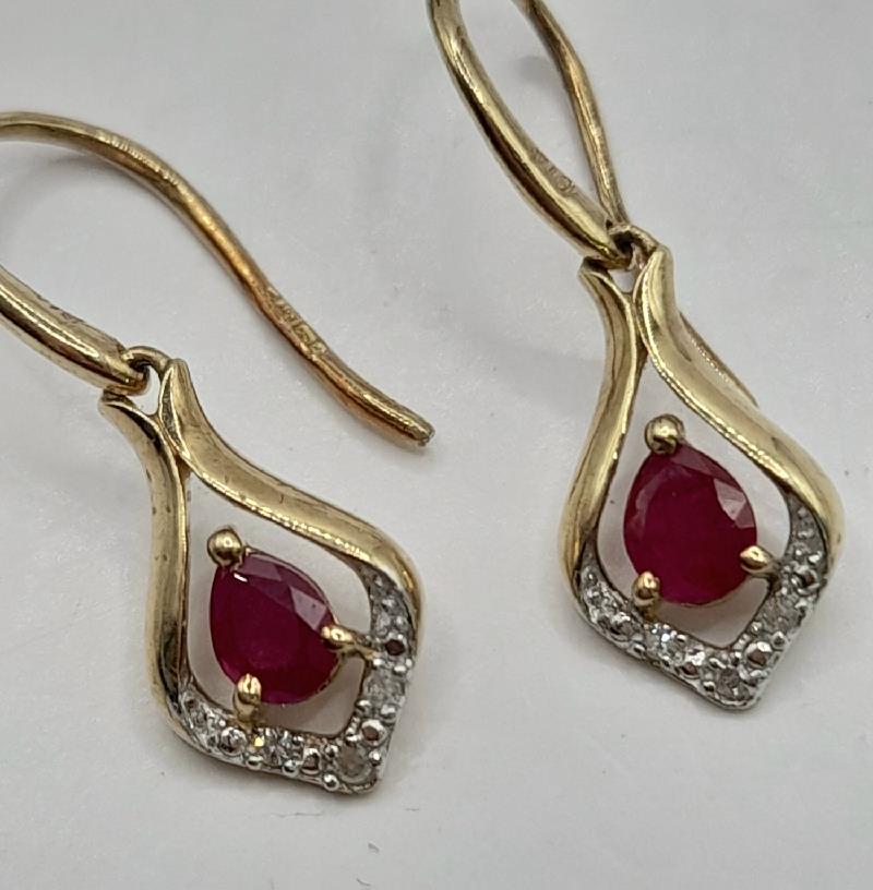 9ct gold Ruby earrings featuring vibrant red rubies set in elegant gold, displayed on a plain background.
