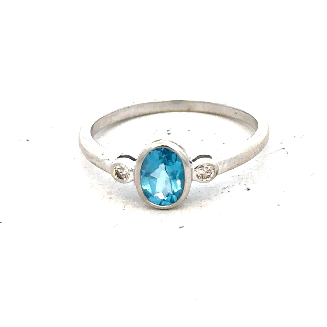9ct white gold topaz and diamond ring, size Q, featuring a central blue topaz with diamond accents on a sleek band.