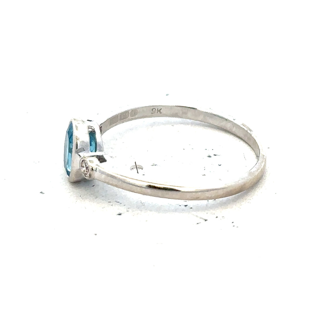 9ct white gold ring with blue topaz and diamond accents in size Q, showcasing elegant jewelry design.