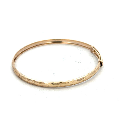 9ct yellow gold bangle weighing 1.7g, unbranded, with a smooth polished finish, displayed on a neutral background.