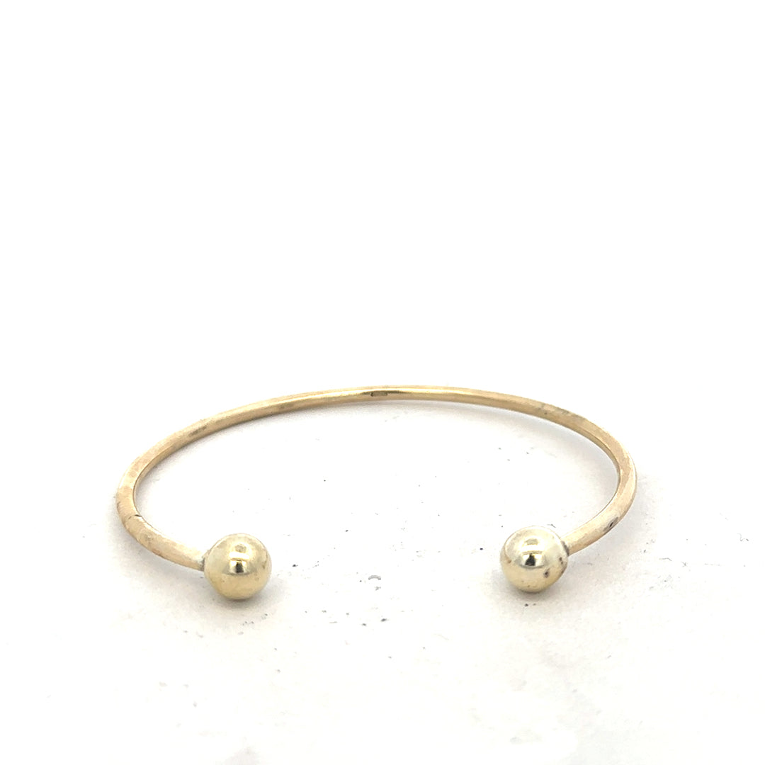 9ct yellow gold bangle weighing 12.7g, unbranded, with a smooth, polished finish, displayed on a neutral background.