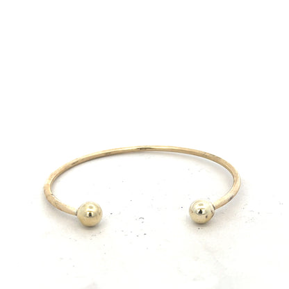 9ct yellow gold bangle weighing 12.7g, unbranded, with a smooth, polished finish, displayed on a neutral background.