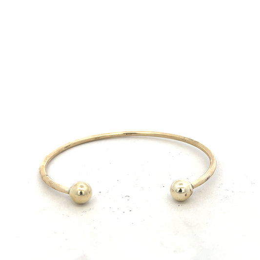 9ct yellow gold bangle weighing 12.7g, unbranded, with a smooth, polished finish, displayed on a neutral background.
