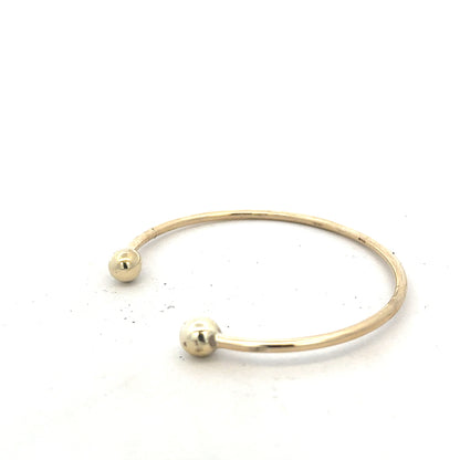 9ct yellow gold bangle weighing 12.7g, unbranded, with a smooth polished finish and rounded shape, displayed on a white background.