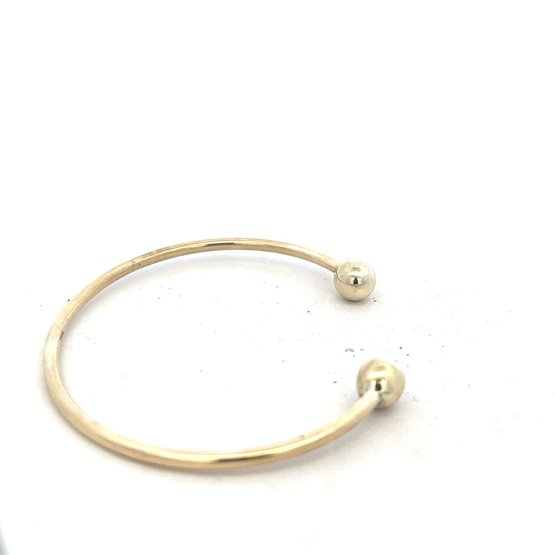 9ct yellow gold bangle weighing 12.7g, unbranded jewelry accessory, showcasing a smooth, polished gold finish.