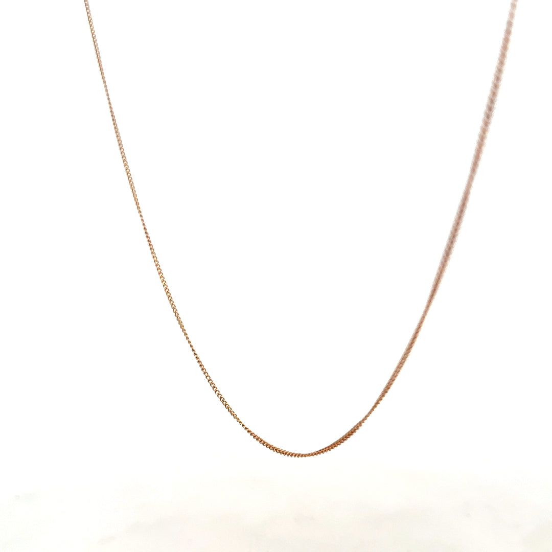 9ct yellow gold chain weighing 1.4g, unbranded jewelry with a sleek, polished finish, shown lying flat.