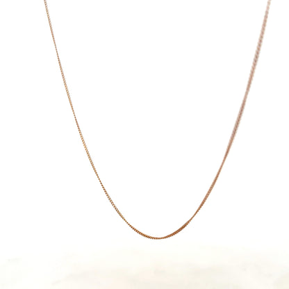 9ct yellow gold chain weighing 1.4g, unbranded jewelry with a sleek, polished finish, shown lying flat.
