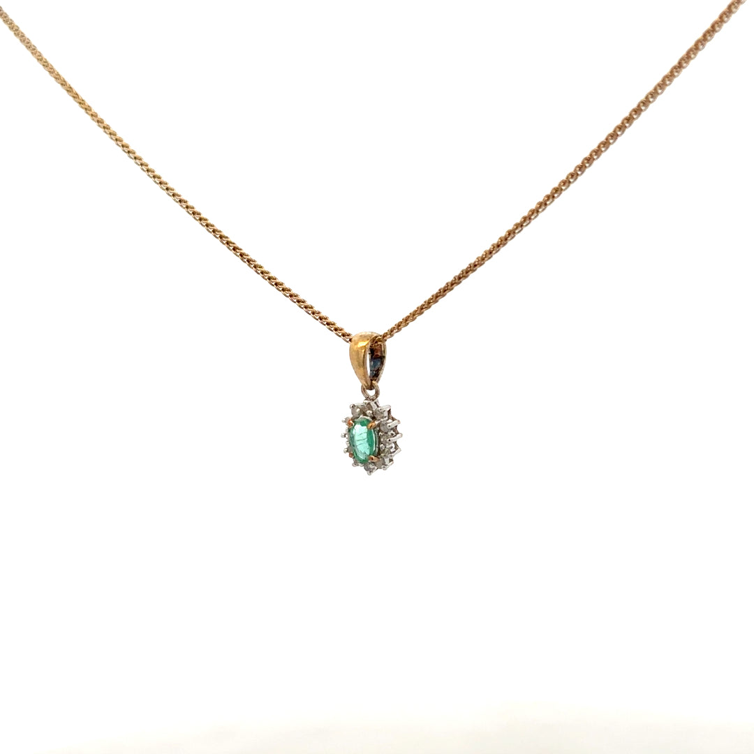 9ct yellow gold chain with emerald and diamond pendant, showcasing a delicate design and vibrant gemstones.