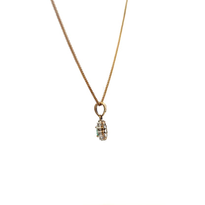 9ct yellow gold chain with emerald and diamond pendant, detailed close-up showing the jewelry's elegant design and precious stones.