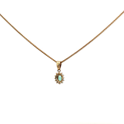 9ct yellow gold chain with emerald and diamond pendant, showcasing a delicate jewelry piece with vibrant gemstones and elegant design.