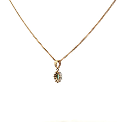9ct yellow gold chain with emerald and diamond pendant, featuring a delicate design and sparkling gemstones.