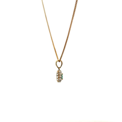 9ct yellow gold chain with emerald and diamond pendant, showcasing a delicate, elegant jewelry piece with vibrant gemstones.