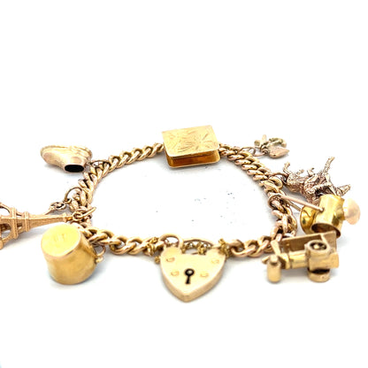 9ct yellow gold charm bracelet with detailed charms, weighs 28.1g, featuring a classic design and secure clasp.