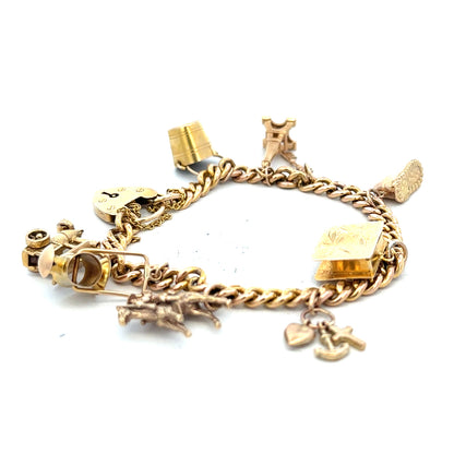 9ct yellow gold charm bracelet weighing 28.1g, featuring decorative charms and intricate details, unbranded jewelry piece.