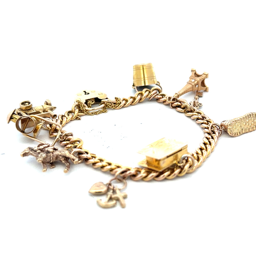 9ct yellow gold charm bracelet with intricate charms, weighs 28.1g, featuring a secure clasp and polished finish.