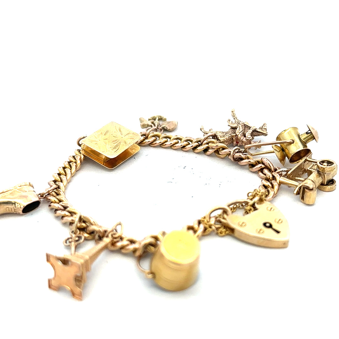 9ct yellow gold charm bracelet with intricate links, weighing 28.1g, featuring decorative charms and elegant craftsmanship.