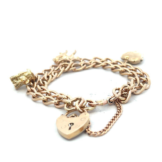9ct yellow gold charm bracelet with intricate designs, weighs 28.5g, featuring various decorative charms and links.