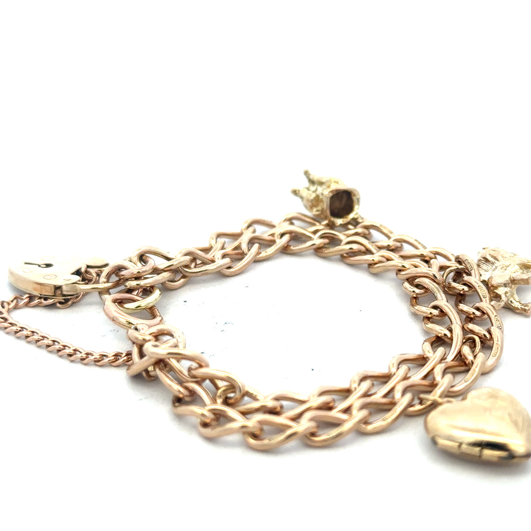 9ct yellow gold charm bracelet with intricate designs, weighs 28.5g, featuring various decorative charms and links.