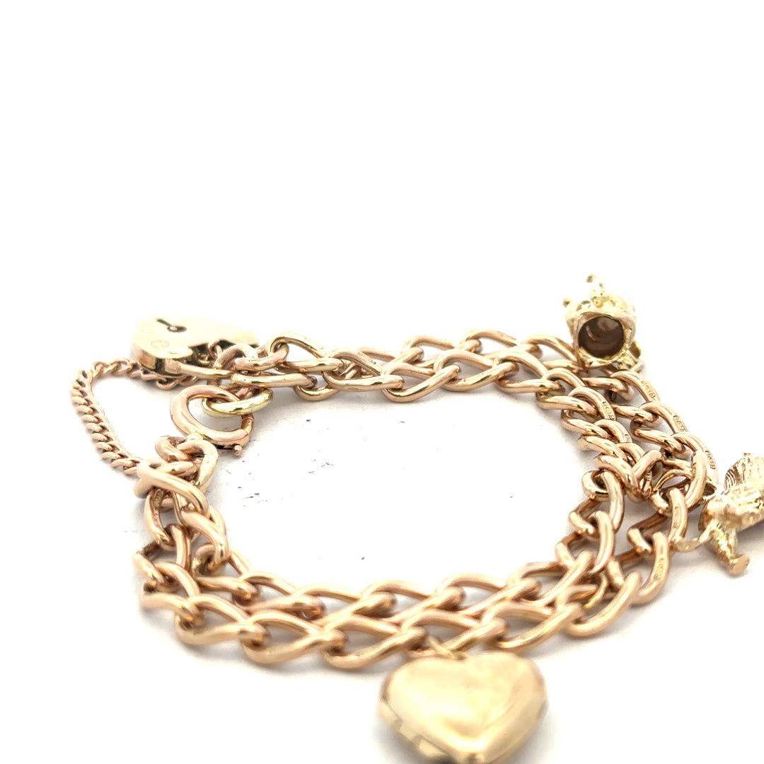 9ct yellow gold charm bracelet weighing 28.5g, featuring various decorative charms on a delicate gold chain.