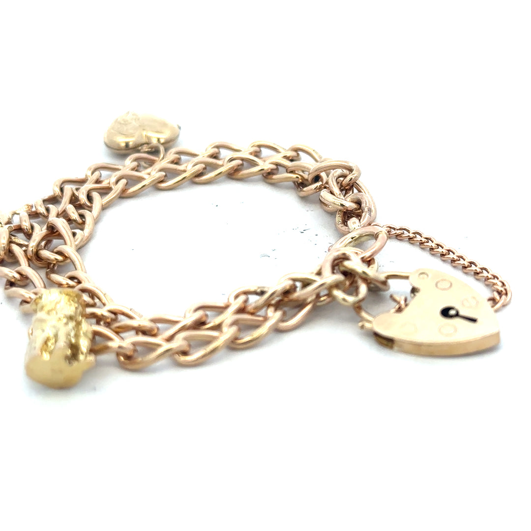 9ct yellow gold charm bracelet weighing 28.5g, unbranded, with intricate charm details visible on a neutral background.