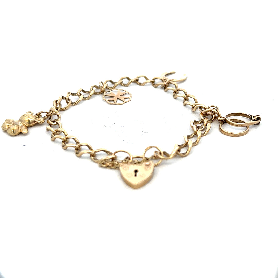 9ct yellow gold charm bracelet weighing 9.9g, featuring various decorative charms and a secure clasp.
