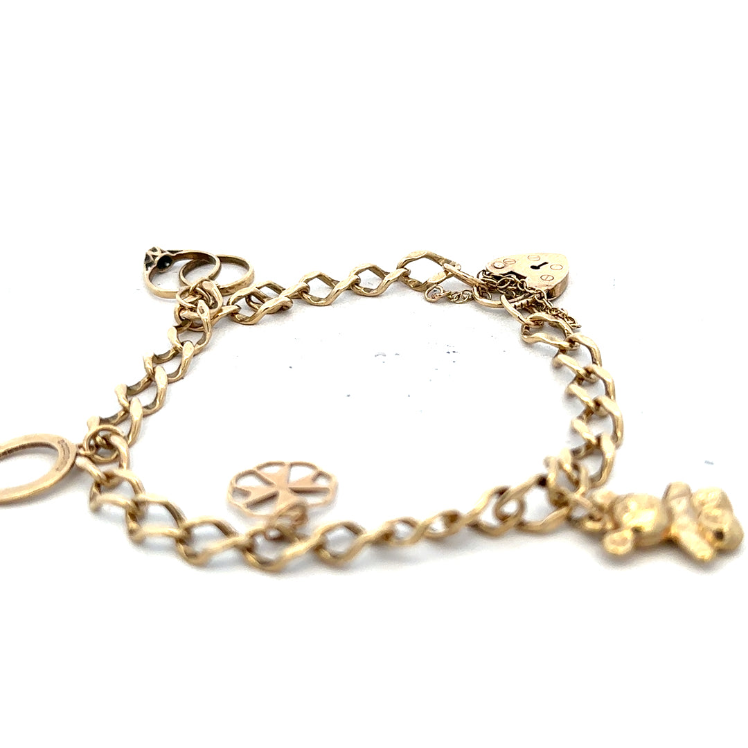 9ct yellow gold charm bracelet weighing 9.9g with decorative charms, unbranded jewelry accessory.