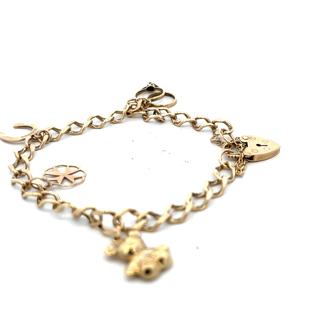 9ct yellow gold charm bracelet with intricate details, weighing 9.9g, featuring various decorative charms on a delicate chain.