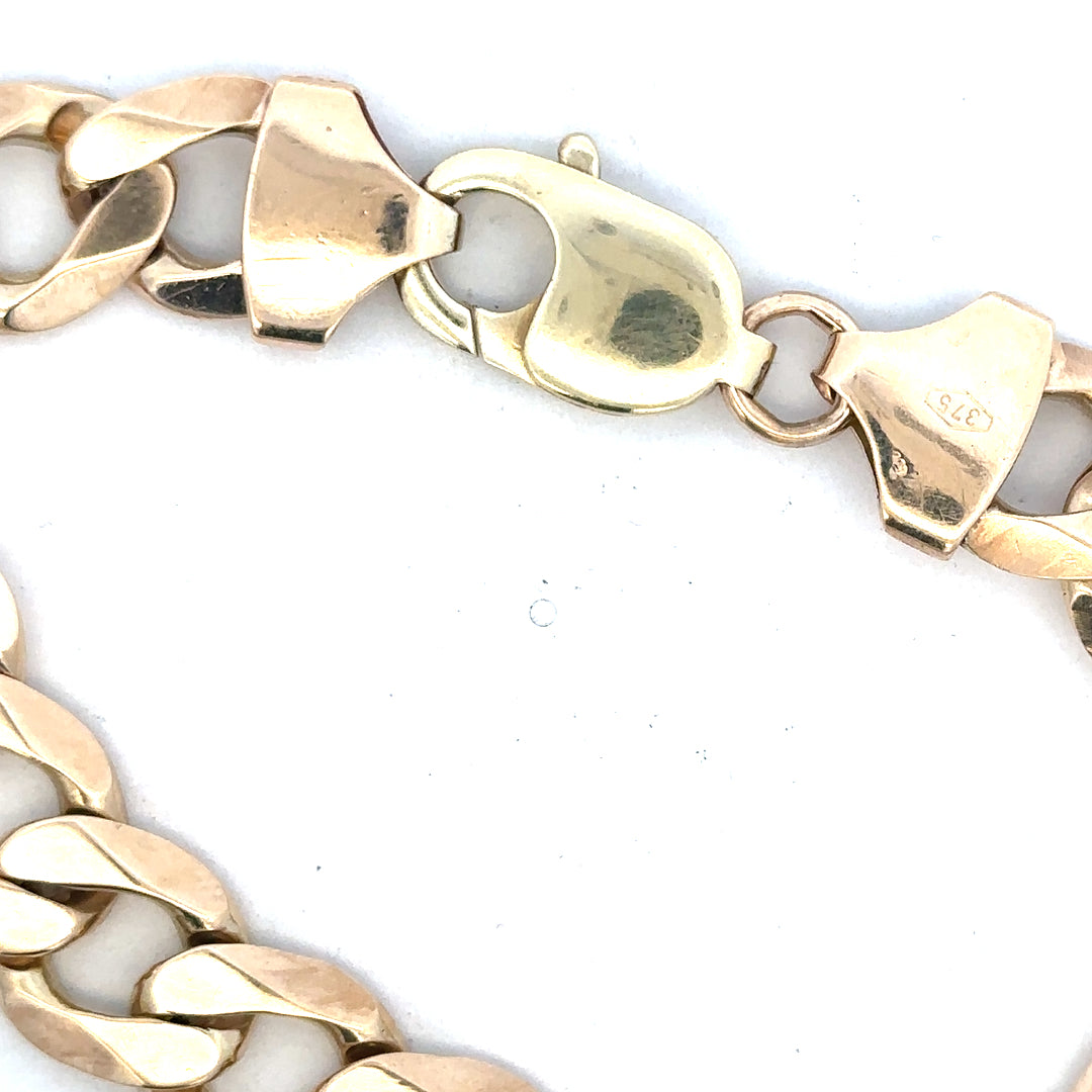 9ct yellow gold curb bracelet with a sturdy chain design, weighs 52.6g, unbranded jewelry piece, close-up view.