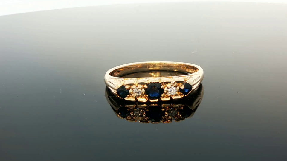 9ct yellow gold ring with diamonds and sapphires, featuring a detailed design, displayed on a white background.