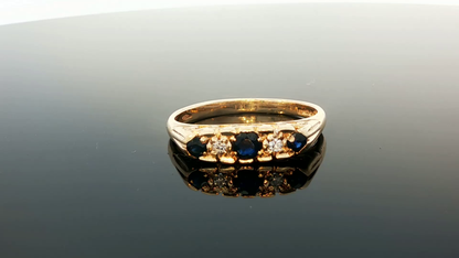 9ct yellow gold ring with diamonds and sapphires, featuring a detailed design, displayed on a white background.