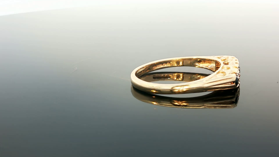 9ct yellow gold diamond and sapphire ring with intricate design, featuring sparkling stones and a polished finish.