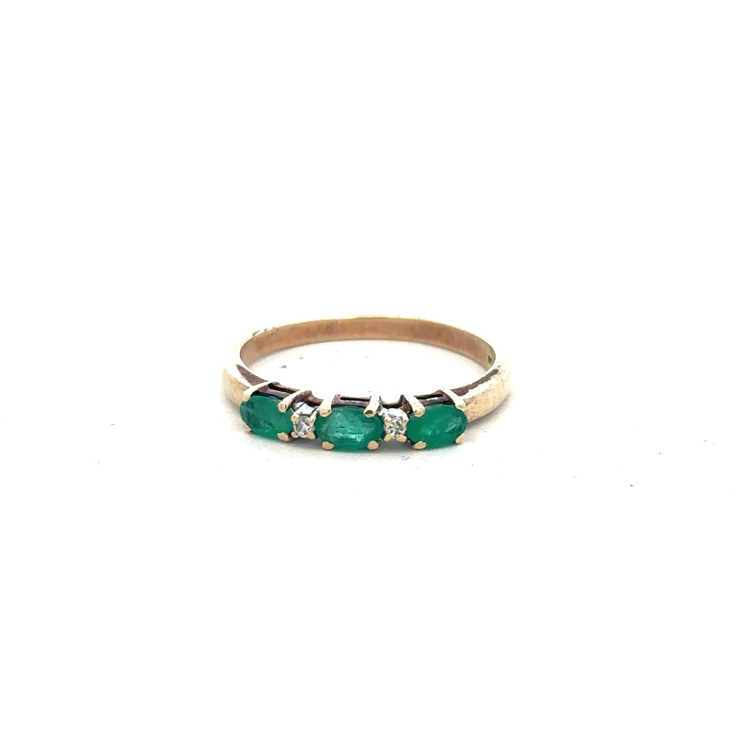 9ct yellow gold emerald and diamond ring in size T, featuring a central emerald surrounded by small diamonds.