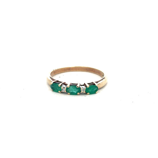 9ct yellow gold emerald and diamond ring in size T, featuring a central emerald surrounded by small diamonds.