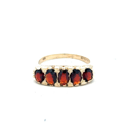 9ct yellow gold garnet ring in size S featuring a vibrant red garnet gemstone set in a polished gold band.