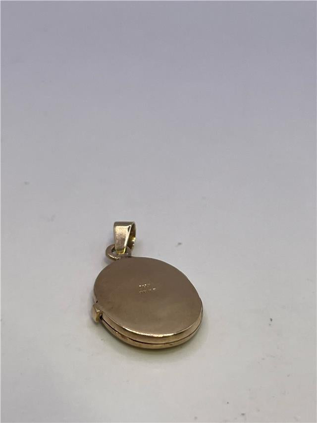 9ct yellow gold locket weighing 3.5g, unbranded, with intricate engraved design and hinged front, showcasing jewelry craftsmanship.
