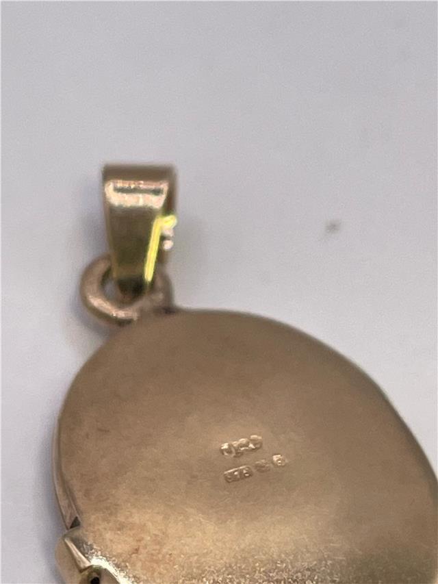 9ct yellow gold locket weighing 3.5g, unbranded jewelry with intricate design and secure clasp, shown in close-up image.