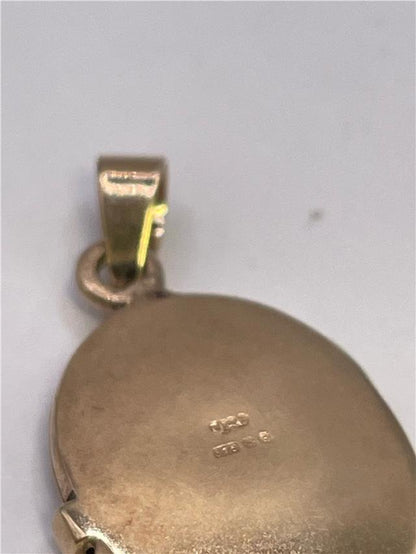 9ct yellow gold locket weighing 3.5g, unbranded jewelry with intricate design and secure clasp, shown in close-up image.